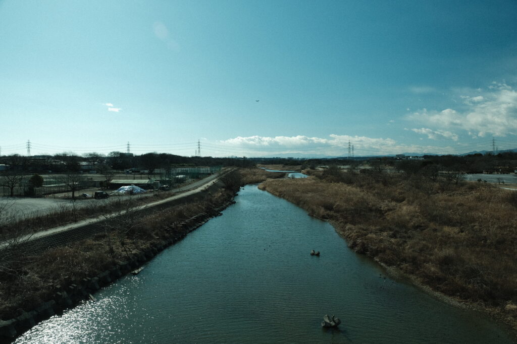 狭山市の入間川河川敷遊歩道をウォーキングする様子